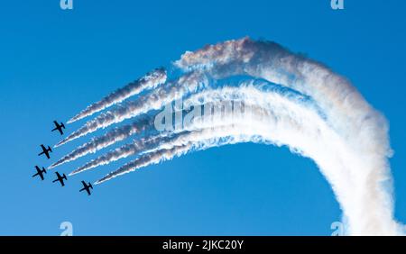 Silhouettes of training aircraft performing aerobatics on a clear sunny day. Stock Photo