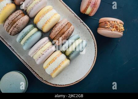 Colorful french macarons on plate on black background Stock Photo