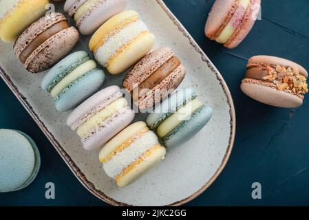 Colorful french macarons on plate on black background Stock Photo