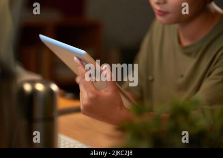 Hands of young woman holding tablet computer and surfing the Net Stock Photo