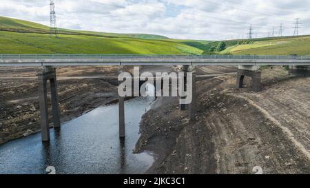 Remnants of an old bridge that’s usual submerged under water is full exposed as water in the reservoir is severally depleted at Baitings Reservoir near Ripponden West Yorkshire, UK on the 01/08/2022 Stock Photo