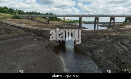 Remnants of an old bridge that’s usual submerged under water is full exposed as water in the reservoir is severally depleted at Baitings Reservoir near Ripponden West Yorkshire, UK on the 01/08/2022 Stock Photo