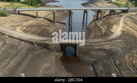 Remnants of an old bridge that’s usual submerged under water is full exposed as water in the reservoir is severally depleted at Baitings Reservoir near Ripponden West Yorkshire, UK on the 01/08/2022 Stock Photo