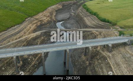 Remnants of an old bridge that’s usual submerged under water is full exposed as water in the reservoir is severally depleted at Baitings Reservoir near Ripponden West Yorkshire, UK on the 01/08/2022 Stock Photo