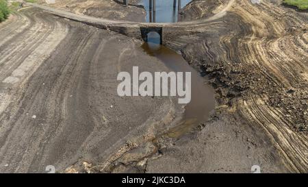 Remnants of an old bridge that’s usual submerged under water is full exposed as water in the reservoir is severally depleted at Baitings Reservoir near Ripponden West Yorkshire, UK on the 01/08/2022 Stock Photo