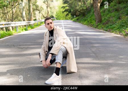 Young Hispanic Arab man posing on the road, gazing into infinity, copy space Stock Photo