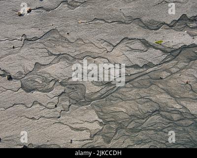 Rivulets of water on a fine sand beach at low tide. Stock Photo