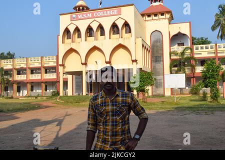 Indian young male college student standing in front of the college and posing for photo Stock Photo