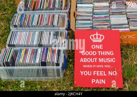 One Good Thing about Music when it hits you you feel no pain sign on stall with CDs at Chettle Village fete, Chettle, Dorset UK in July Stock Photo