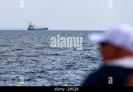 Odesa, Ukraine. 01st Aug, 2022. A man looks on as the Sierra Leone-flagged cargo ship RAZONI loaded with 26,000 tonnes of Ukrainian corn as leaves the Ukraine's Odesa port heading to the port of Tripoli in Lebanon after restarting grain export, in Odesa. On July 22, an agreement was signed on the export of grain and other foodstuffs from the ports of Ukraine following a quadrilateral meeting of Ukraine, Turkey, the UN, and Russia in Istanbul, as earlier media reported. Credit: SOPA Images Limited/Alamy Live News Stock Photo