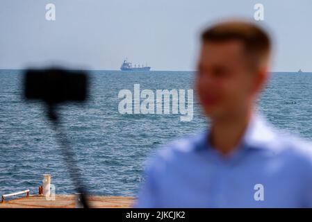 Odesa, Ukraine. 01st Aug, 2022. A man takes a selfie in front of the Sierra Leone-flagged cargo ship RAZONI loaded with 26,000 tonnes of Ukrainian corn as it leaves the Ukraine's Odesa port heading to the port of Tripoli in Lebanon after restarting grain export, in Odesa. On July 22, an agreement was signed on the export of grain and other foodstuffs from the ports of Ukraine following a quadrilateral meeting of Ukraine, Turkey, the UN, and Russia in Istanbul, as earlier media reported. Credit: SOPA Images Limited/Alamy Live News Stock Photo