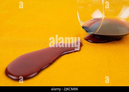 a spilled glass of wine on the tablecloth. Cleaning clothes and furniture from stains Stock Photo