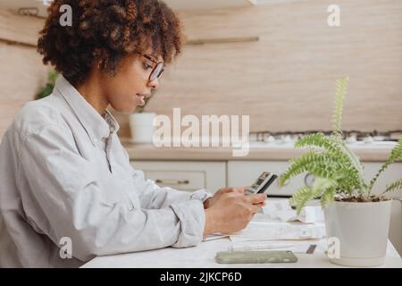 The homeowner calculates the new prices in the kitchen. Stock Photo