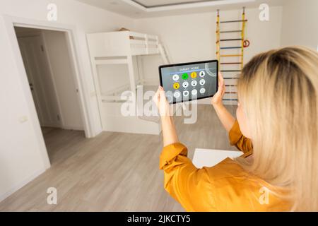 Woman using smart wall home control system. Stock Photo