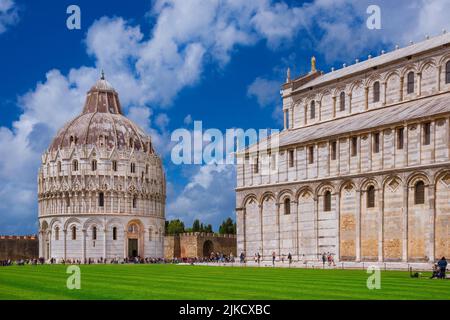 Sightseeing in Tuscany. Tourists visit the famous Campo dei Miracoli (Miracles' Square) with medieval Baptistery and Cathedral in Pisa Stock Photo