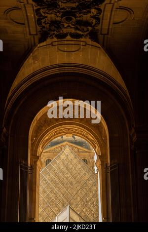 A vertical shot of the Louvre from behind the arch, Paris, France Stock Photo