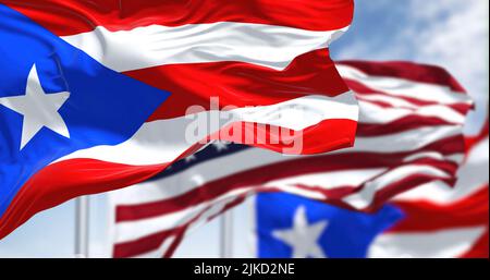 Flags of Puerto Rico waving in the wind with the United States flag on a clear day. Puerto Rico is a Caribbean island and unincorporated territory of Stock Photo