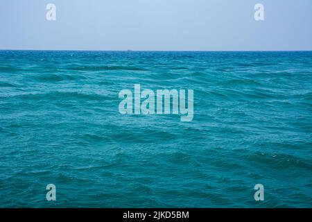 Beautiful sea with turquoise colored waves. Sea waves in the open sea, a boat can be seen on the horizon. Stock Photo