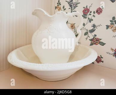 Vintage ivory bowl and pitcher with retro wallpaper background Stock Photo