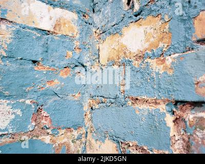 Close up of grungy faded blue paint on corner brick wall Stock Photo