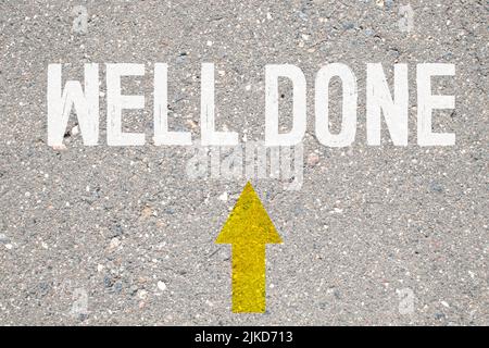 Business concept. On the asphalt road markings an arrow with the inscription - WELL DONE. Stock Photo