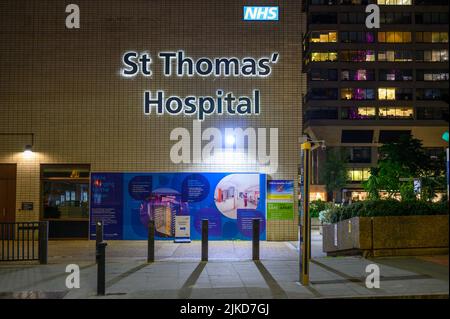LONDON - May 17, 2022: Illuminated St Thomas' Hospital sign on side of building at night