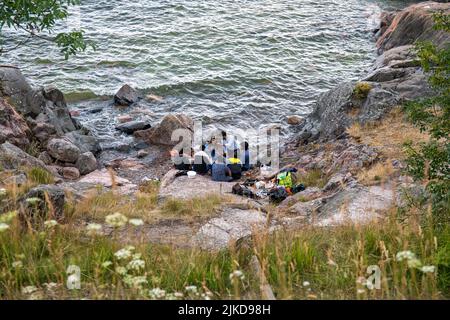 High-angle view of people having a picnic at little cove in Susisaari island of Suomenlinna district, Helsinki, Finland Stock Photo