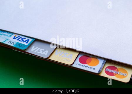 Moscow, Russia, August 2019: Notepad with credit cards: Visa, Visa gold, Visa electron, Mastercard gold. Logos look out from a notepad with space for Stock Photo