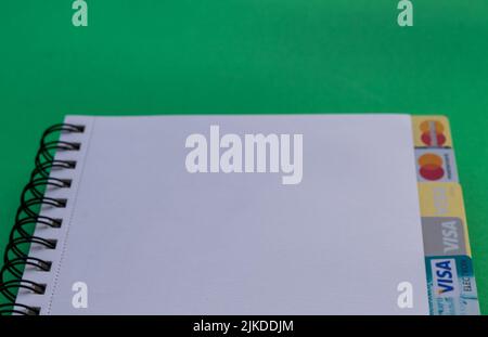 Moscow, Russia, August 2019: Credit cards: Visa, Visa gold, Visa electron and blurred Mastercard, Mastercard gold. Logos look out from a white paper w Stock Photo