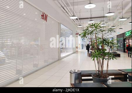 Moscow, Russia, March 2022: HM store suspends work in Russia. Brand shops in the shopping mall are closed. Customers are passing by. Stock Photo