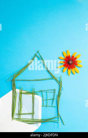 House made of grass straws,  on  a blank envelope, on blue background Stock Photo