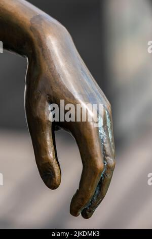 bronze sculpted hand close up, sculpture of a hand made from bronze, cast brinze model of ahand with fingers, limp wristed hand cast from metal. Stock Photo