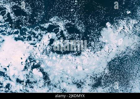 Natural background of ice on the river. Textured cold frosty surface of ice on the river. Ice texture in blue and white tones. Textured cold frosty Stock Photo