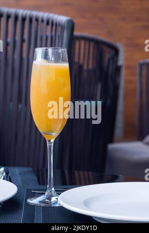 A glass of orange freshly squeezed natural juice on a table in a restaurant. Proper nutrition. vertical composition. Stock Photo