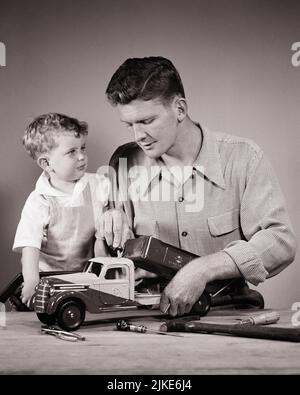 1940s TODDLER BOY WITH HIS FATHER REPAIRING A TOY TRUCK - j10763 HAR001 HARS SATISFACTION STUDIO SHOT HOME LIFE COPY SPACE FRIENDSHIP HALF-LENGTH PERSONS INSPIRATION CARING MALES FIXING FATHERS B&W TRUCKS HIS DADS FATHER AND SON REPAIRING CONNECTION CONCEPTUAL FATHERS AND SONS MALE BONDING BABY BOY PERSONAL ATTACHMENT AFFECTION EMOTION GROWTH JUVENILES SOLUTIONS TOGETHERNESS YOUNG ADULT MAN BLACK AND WHITE CAUCASIAN ETHNICITY HAR001 OLD FASHIONED Stock Photo