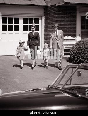 1950s MOTHER FATHER AND TWO YOUNG CHILDREN WALKING DOWN DRIVEWAY TO THEIR CAR - j1156 HAR001 HARS HUSBAND DAD FOUR MOM HATS CLOTHING NOSTALGIC PAIR 4 BEAUTY COMMUNITY SUBURBAN MOTHERS OLD TIME NOSTALGIA BROTHER OLD FASHION AUTO SISTER 1 DRIVEWAY JUVENILE STYLE VEHICLE FAMILIES JOY LIFESTYLE SATISFACTION FEMALES HOUSES MARRIED BROTHERS SPOUSE HUSBANDS HEALTHINESS HOME LIFE COPY SPACE FRIENDSHIP FULL-LENGTH LADIES PERSONS RESIDENTIAL AUTOMOBILE MALES BUILDINGS SIBLINGS SISTERS TRANSPORTATION FATHERS MIDDLE-AGED B&W PARTNER SUCCESS SUIT AND TIE HAPPINESS AND AUTOS DADS EXTERIOR PRIDE Stock Photo