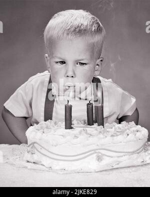 1950s BLONDE THREE YEAR OLD BOY BLOWING OUT THE CANDLES ON HIS BIRTHDAY CAKE - j4596 HAR001 HARS CAKES HOME LIFE COPY SPACE MALES CONFIDENCE WISHING B&W GOALS HAPPINESS HEAD AND SHOULDERS HIS EXCITEMENT PARTIES CONCEPTUAL WISH BIRTHDAYS GROWTH JUVENILES YOUNGSTER BLACK AND WHITE CAUCASIAN ETHNICITY HAR001 OLD FASHIONED Stock Photo