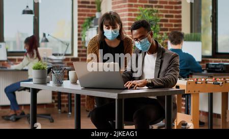 Diverse team of coworkers analyzing charts information on documents, using research data to plan business project. Creating online presentation with corporate report and successful plan. Stock Photo