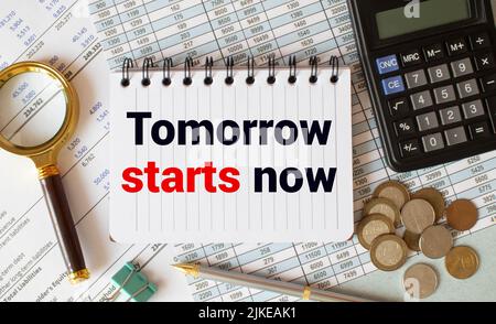 Tomorrow starts now written in a notebook with coffee and pen. Motivation concept Stock Photo