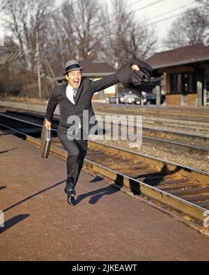 1960s BUSINESS MAN COMMUTER RUNNING BRIEFCASE IN HAND TO CATCH MISSED CONNECTION SUBURBAN TRAIN STATION HAT SUIT AND TIE YELLING - kr11576 HAR001 HARS FULL-LENGTH PERSONS MISSING CARING MALES RISK TRANSPORTATION AFTER LATE SADNESS TRACKS YELLING RAIL SELLING COMMUTERS AND EXCITEMENT IN TO OCCUPATIONS CONNECTION MOTION BLUR MISSED ATTACHE STYLISH RAILROADS FUTILE CHASING MID-ADULT MID-ADULT MAN RUNNING LATE SALESMEN TARDY CAUCASIAN ETHNICITY COMMUTER HAR001 OLD FASHIONED Stock Photo