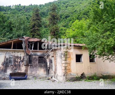 A dilapidated abandoned building in nature. Ruins of an old house. Dwelling. old sofa Stock Photo