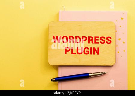 Business concept.Text Wordpress Plugin writing on notepaper with pencil,paper clips and glasses on yellow background. Stock Photo
