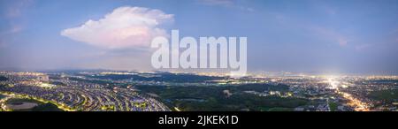 Panoramic view of single cloud over sprawling cityscape at night Stock Photo