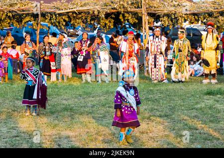 Line up under the arbor around the pow wow arena before they dance, Crow Agency, Montana Stock Photo