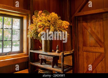 beautiful wooden interior of farm building with a large dried grass and flower arrangement Stock Photo