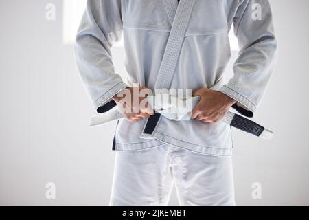 Time to begin. an unrecognizable male martial artist standing with his hands on his belt in the gym. Stock Photo