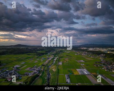 Dramatic clouds over farms and rural landscape at sunset Stock Photo