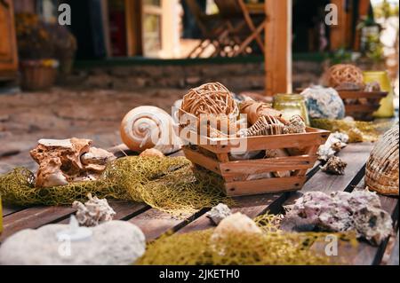 Wooden table in backyard decorated with shells and fishing equipment Stock Photo