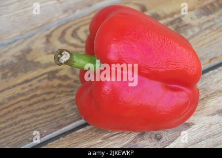 Closeup shot of a red pepper on wooden table. Stock Photo