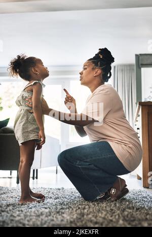 Dont do that again. a young mother reprimanding a child at home. Stock Photo